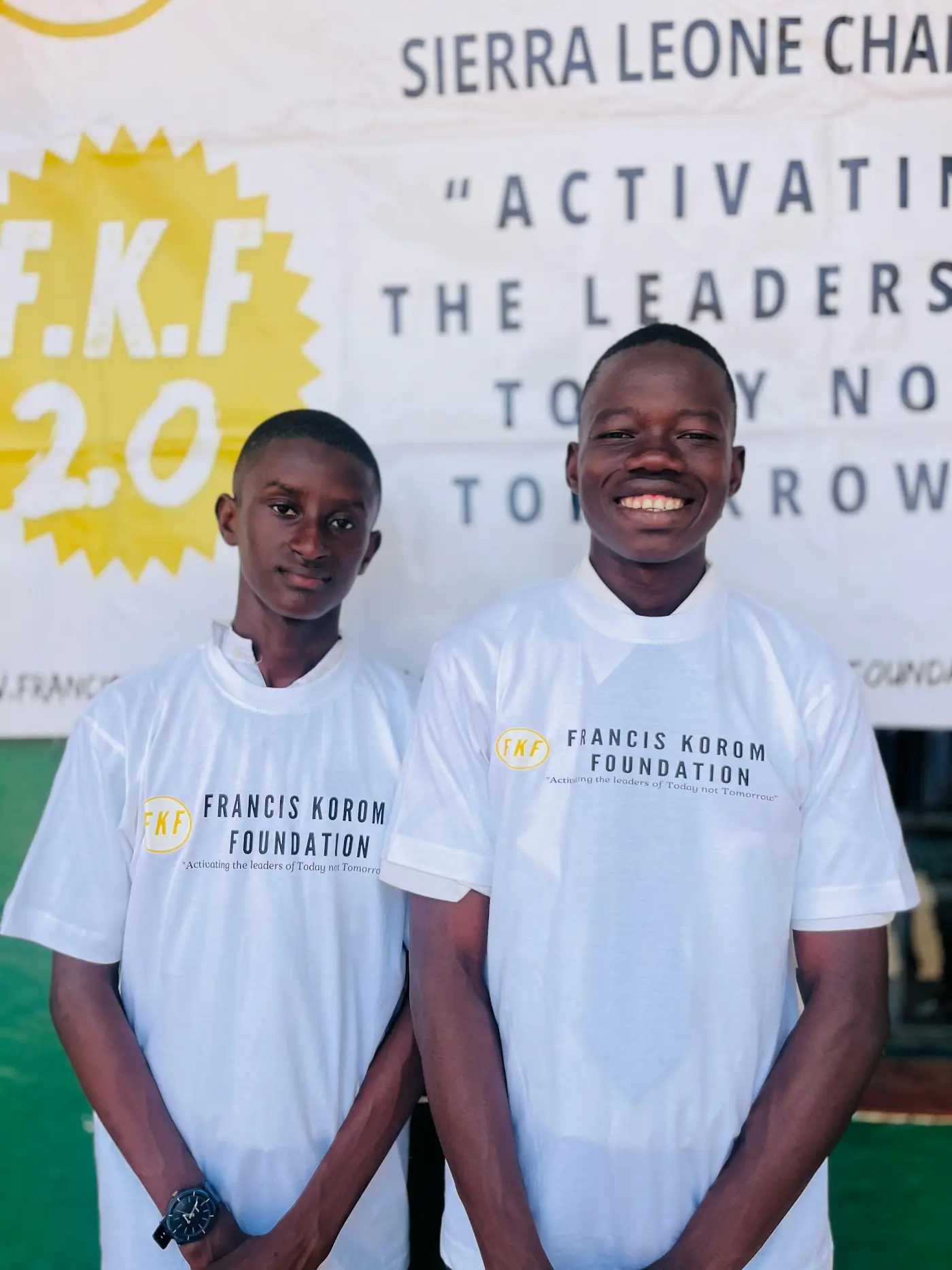 Two students in front of the Sierra Leone chapter banner